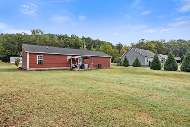 back of house featuring central AC unit and a yard