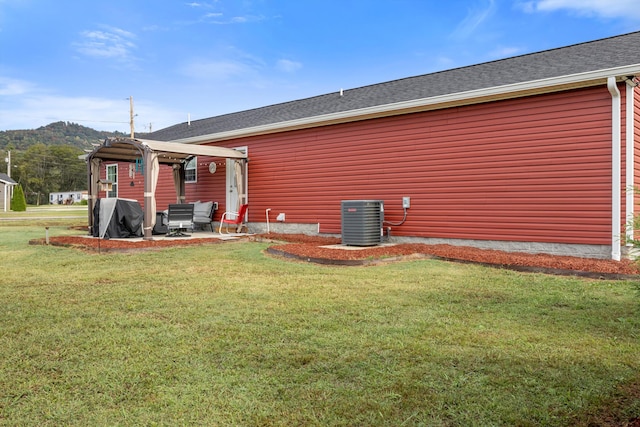 rear view of property featuring a patio, a mountain view, a lawn, a pergola, and central air condition unit