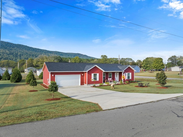 single story home with a mountain view, a garage, and a front lawn