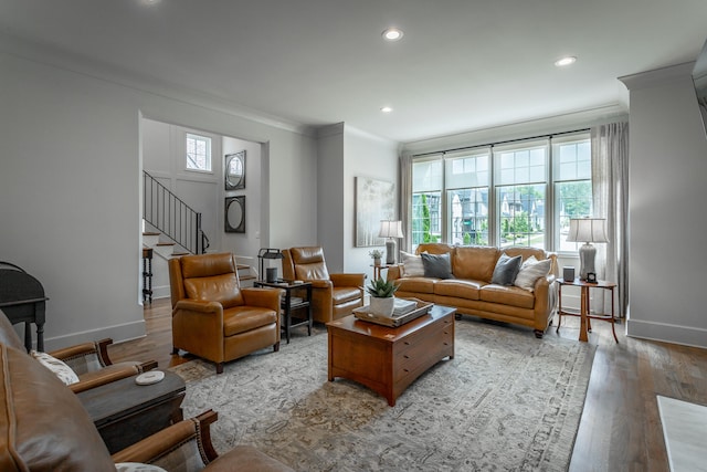 living room with light wood-type flooring, a wealth of natural light, and crown molding