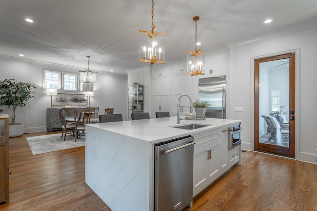 kitchen featuring a kitchen island with sink, white cabinetry, stainless steel appliances, and sink