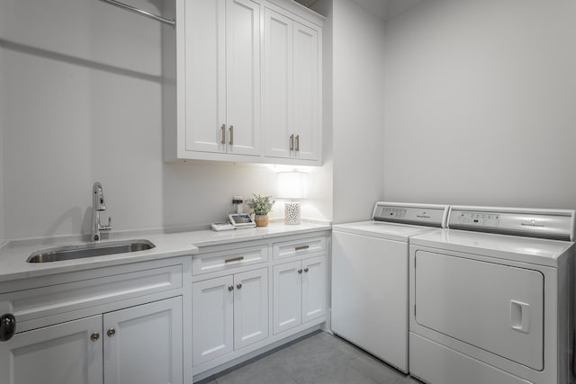 clothes washing area featuring cabinets, independent washer and dryer, and sink