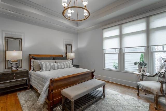 bedroom featuring multiple windows, wood-type flooring, and a chandelier