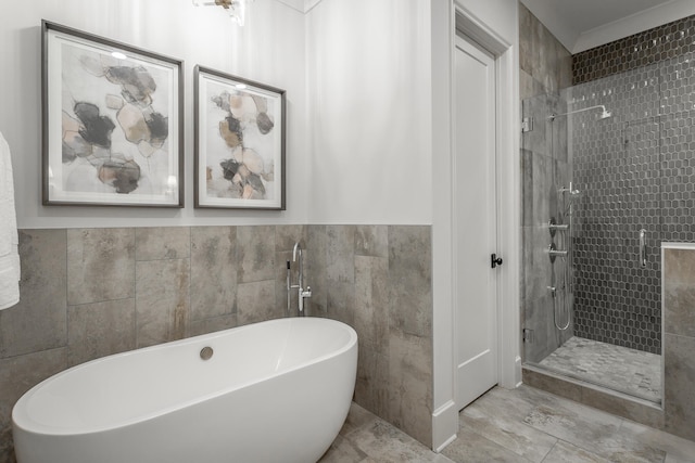 bathroom with tile walls and separate shower and tub