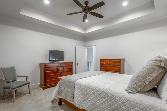 bedroom featuring ceiling fan, crown molding, a raised ceiling, and light carpet