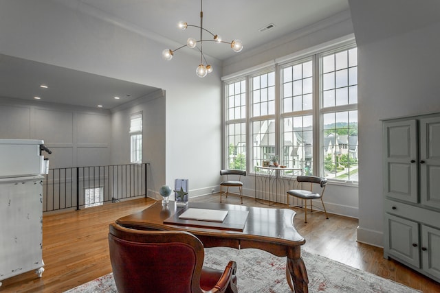 home office with crown molding, a notable chandelier, and light hardwood / wood-style floors