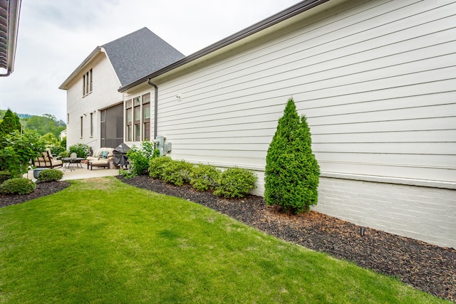 view of property exterior with a yard and a patio area