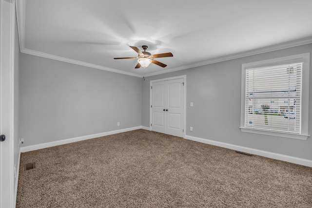 spare room featuring carpet flooring, crown molding, and ceiling fan