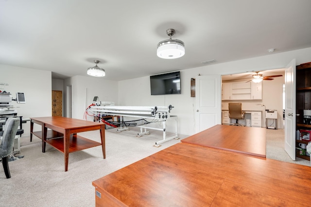 interior space featuring ceiling fan and built in desk