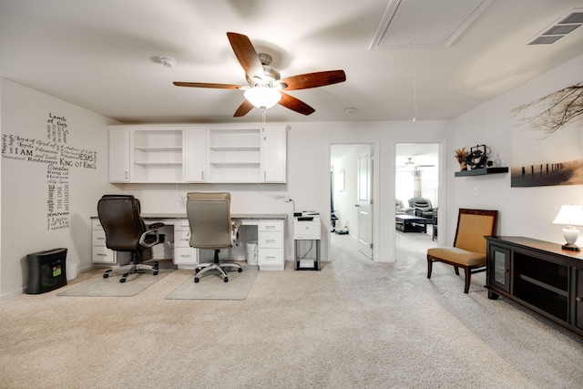 office space with ceiling fan, light colored carpet, and built in desk