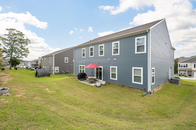 rear view of property with a lawn, a patio, and central AC