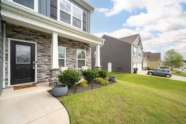 view of exterior entry with a porch and a yard