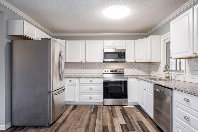 kitchen featuring appliances with stainless steel finishes, white cabinetry, and sink