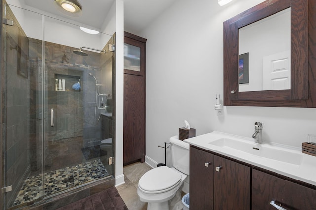 bathroom featuring vanity, toilet, and a shower with door