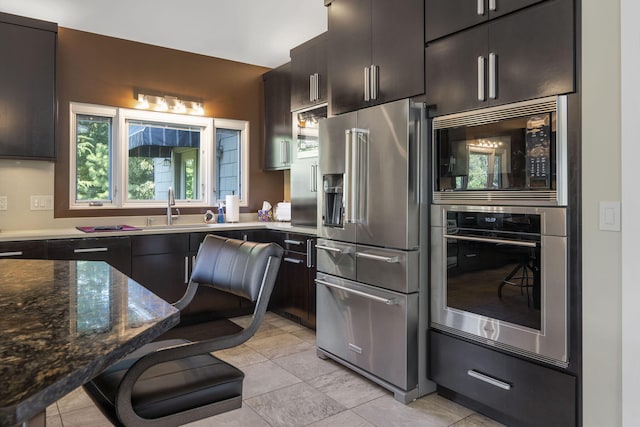 kitchen featuring appliances with stainless steel finishes, sink, and light tile patterned floors