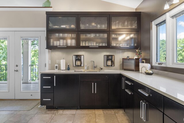 kitchen with vaulted ceiling, light tile patterned floors, and sink