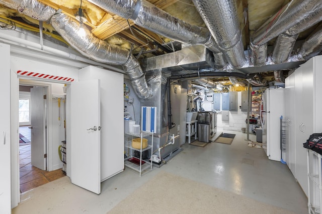 basement with heating unit, electric panel, sink, and white fridge