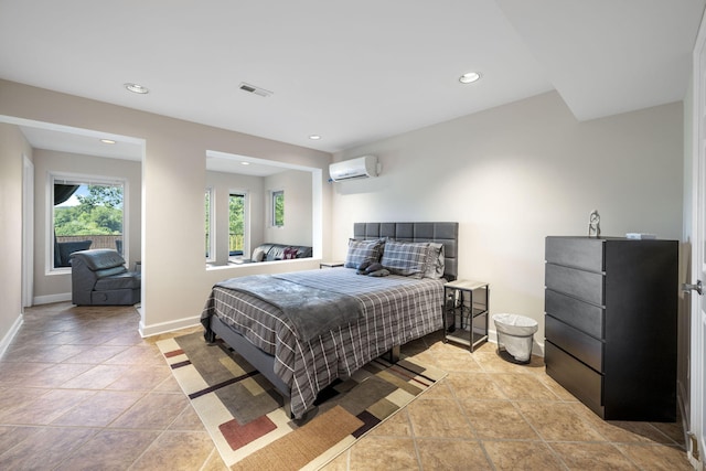 bedroom with an AC wall unit and light tile patterned floors