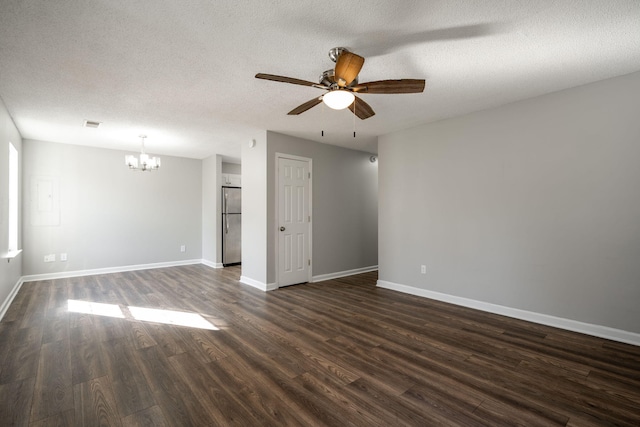 spare room with ceiling fan with notable chandelier, dark wood-type flooring, and a textured ceiling