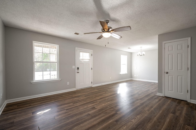 interior space with a textured ceiling, ceiling fan with notable chandelier, and dark hardwood / wood-style floors