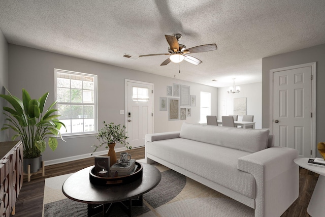 living room with a textured ceiling, ceiling fan with notable chandelier, and dark wood-type flooring