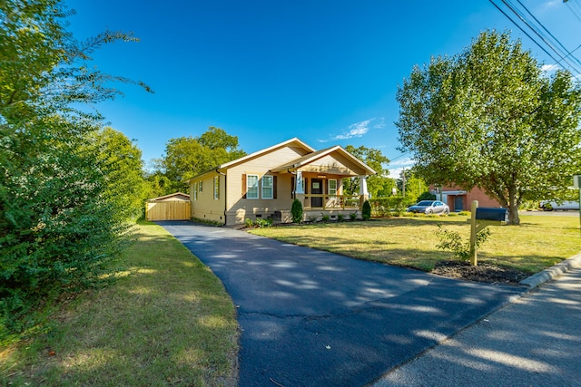 bungalow-style home featuring covered porch and a front yard