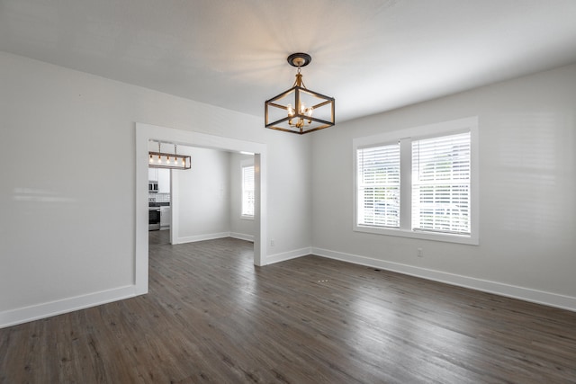 unfurnished room featuring dark hardwood / wood-style floors and a notable chandelier