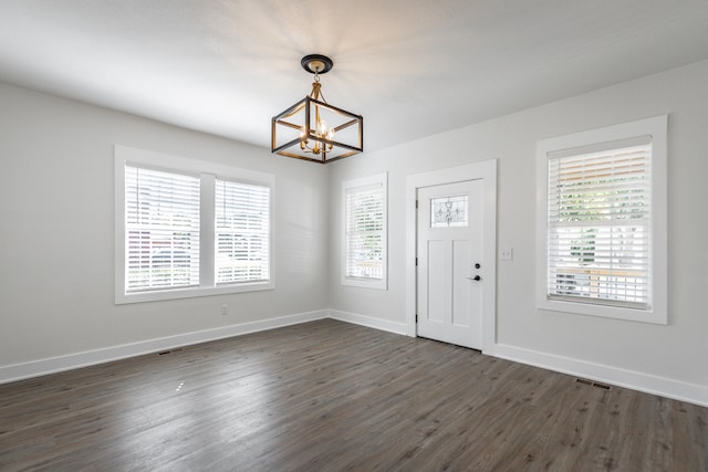 foyer entrance with dark wood-type flooring and a notable chandelier