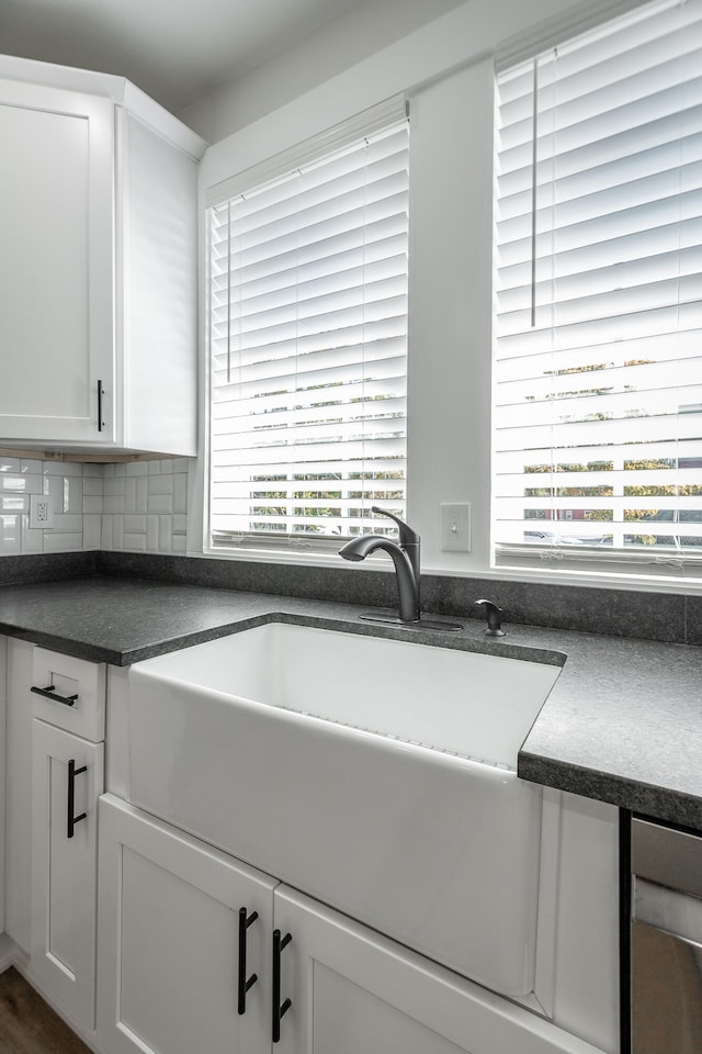 kitchen with white cabinets, sink, decorative backsplash, and a wealth of natural light