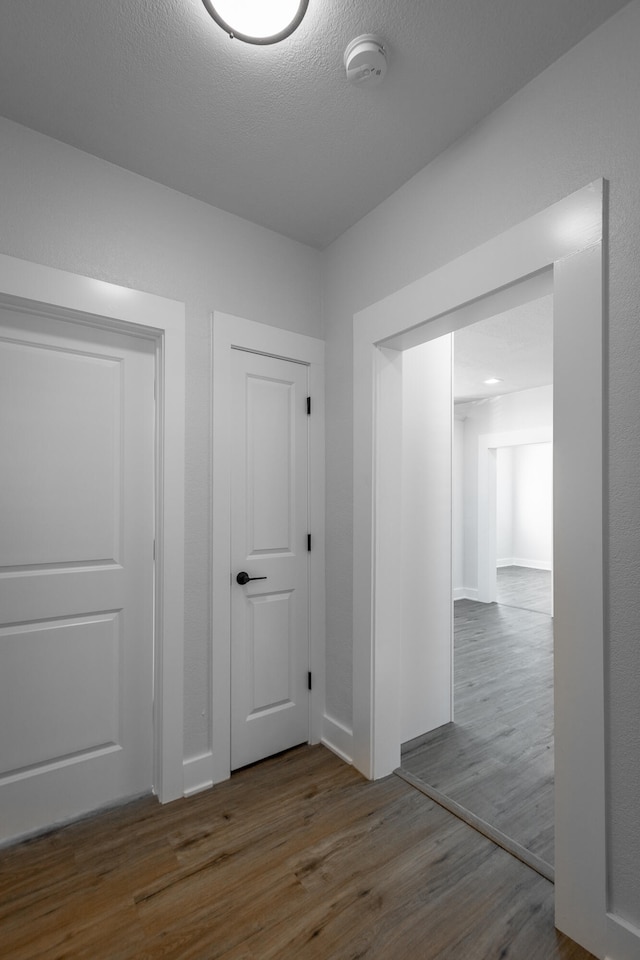 hallway featuring a textured ceiling and hardwood / wood-style floors