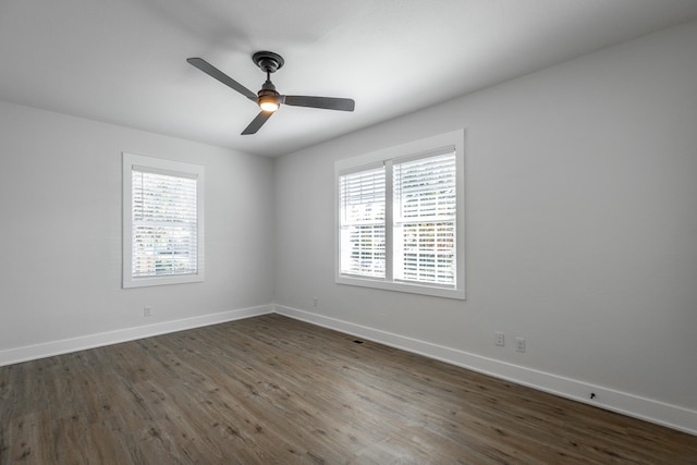 unfurnished room with dark wood-type flooring, ceiling fan, and a healthy amount of sunlight