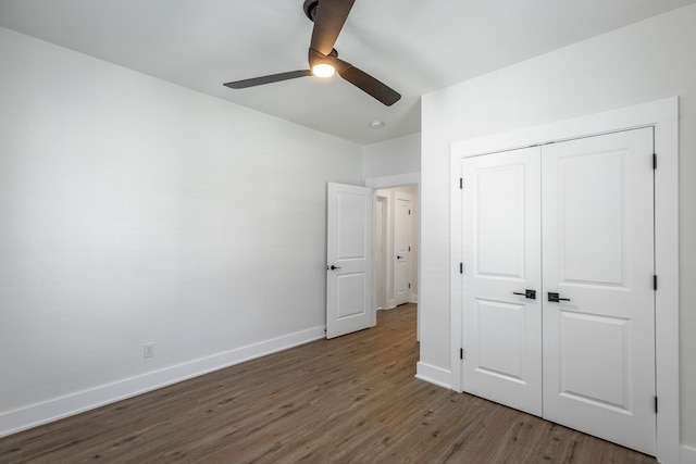 unfurnished bedroom with ceiling fan, a closet, and hardwood / wood-style floors