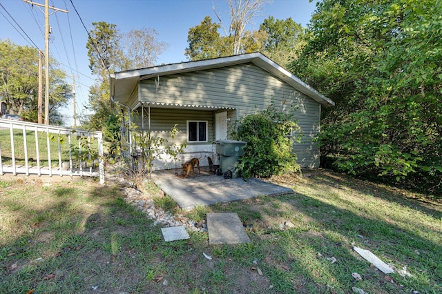 rear view of property featuring a lawn