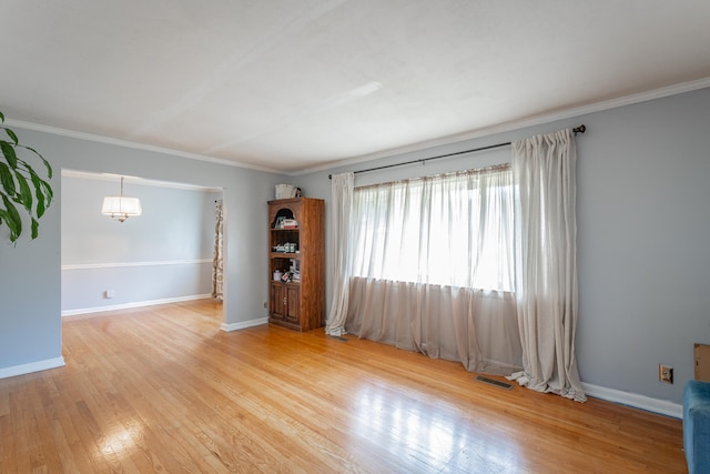 spare room with crown molding and hardwood / wood-style floors