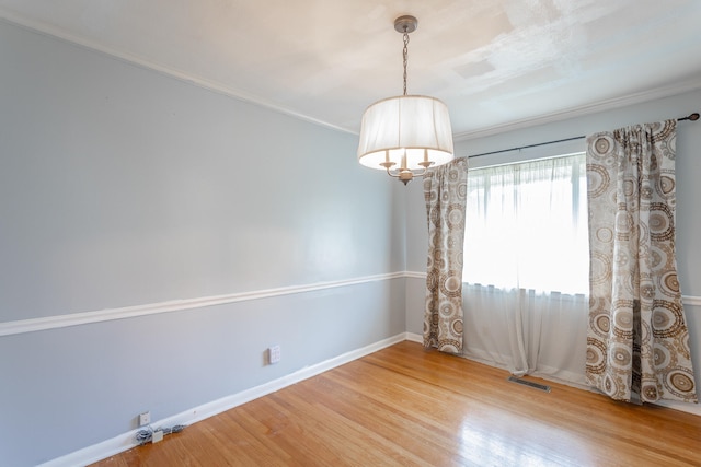 empty room with hardwood / wood-style flooring and ornamental molding