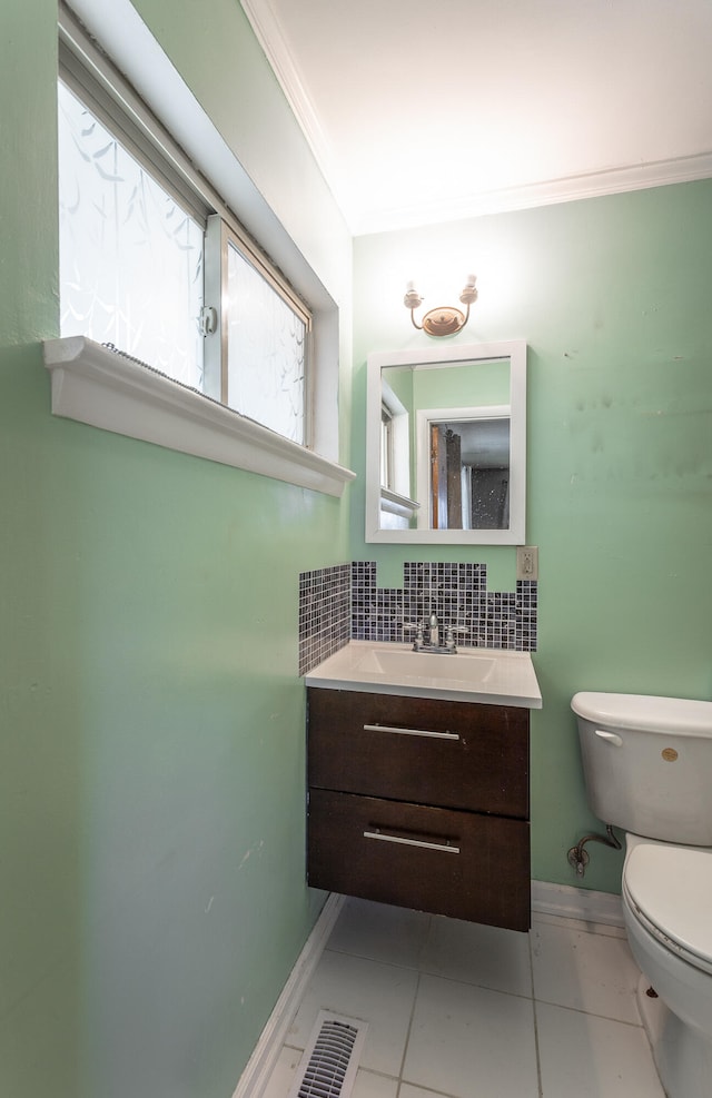 bathroom featuring crown molding, tile patterned flooring, backsplash, vanity, and toilet