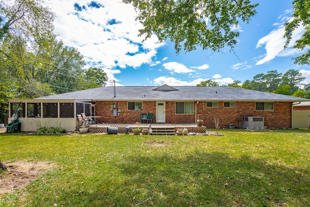 back of property with a yard, a sunroom, and central air condition unit