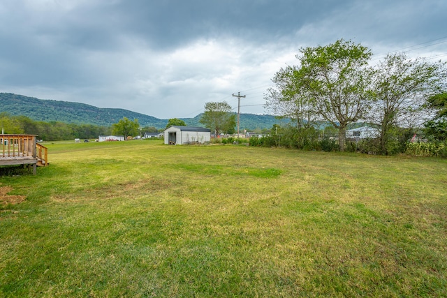 view of yard with a shed and a deck with mountain view