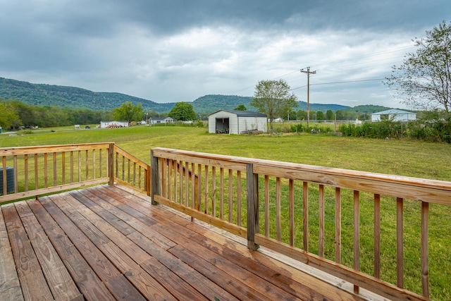 wooden terrace with a mountain view, a yard, and a shed