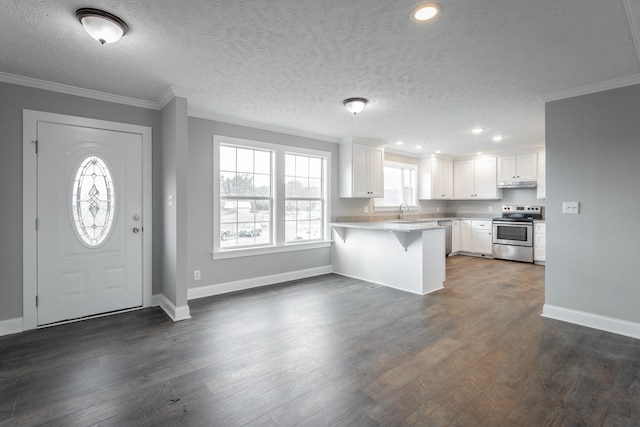 kitchen with white cabinets, a kitchen bar, electric stove, and kitchen peninsula