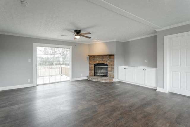 unfurnished living room featuring a stone fireplace, crown molding, ceiling fan, dark hardwood / wood-style floors, and a textured ceiling