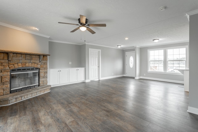 unfurnished living room with ornamental molding, a textured ceiling, ceiling fan, dark wood-type flooring, and a fireplace