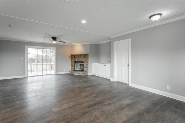 unfurnished living room featuring ceiling fan, dark hardwood / wood-style floors, a stone fireplace, and a textured ceiling