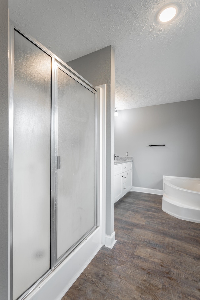 bathroom featuring vanity, wood-type flooring, a textured ceiling, and an enclosed shower