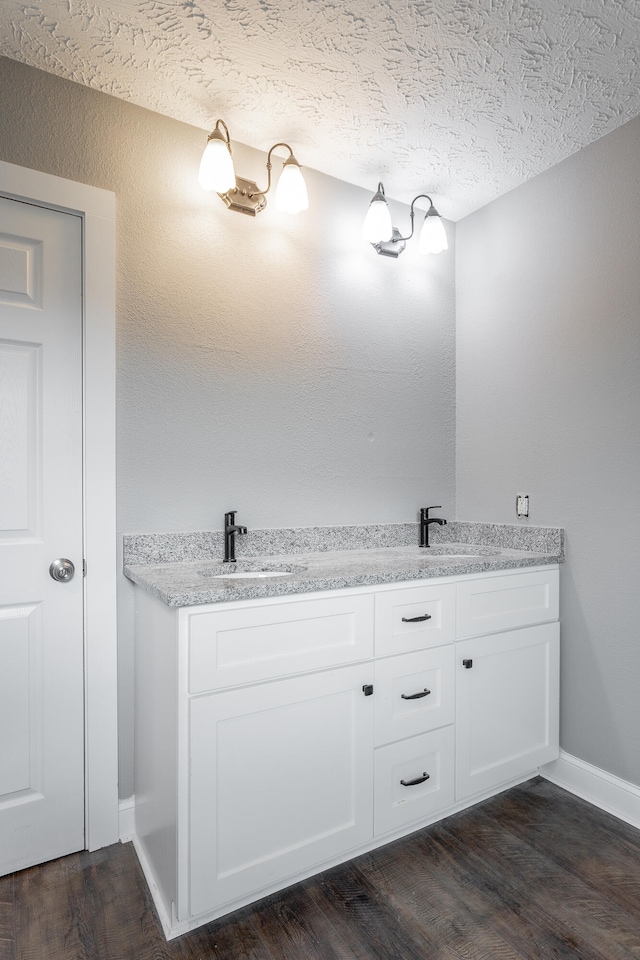 bathroom featuring vanity, wood-type flooring, and a textured ceiling