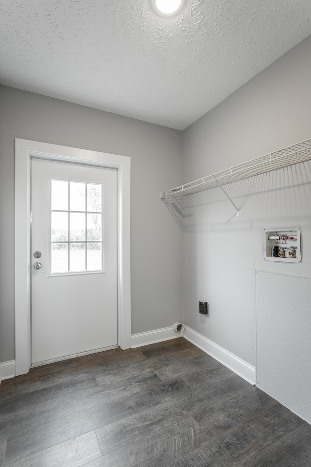 washroom with a textured ceiling, dark wood-type flooring, and hookup for a washing machine