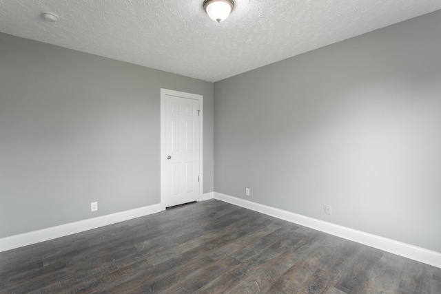 unfurnished room featuring dark hardwood / wood-style flooring and a textured ceiling