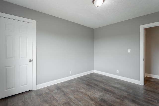 unfurnished room with a textured ceiling and dark hardwood / wood-style flooring