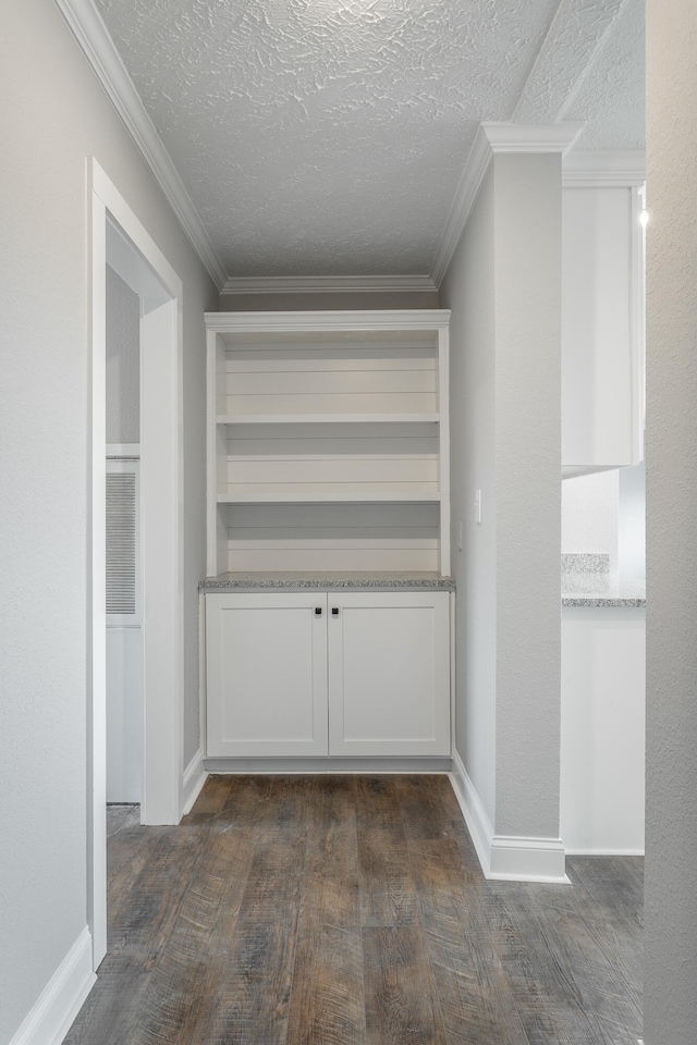 interior space with a textured ceiling, crown molding, and dark hardwood / wood-style floors