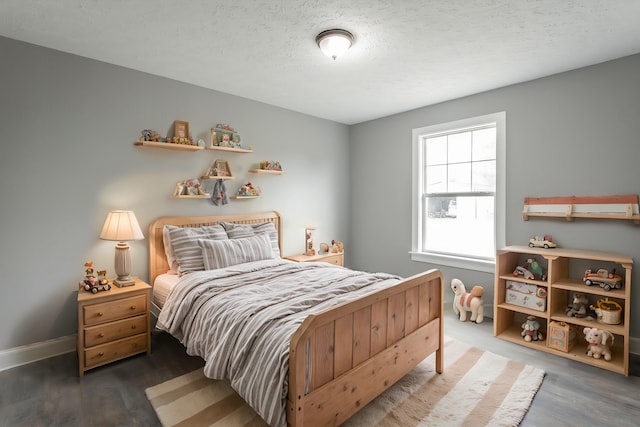 bedroom with a textured ceiling and dark hardwood / wood-style floors